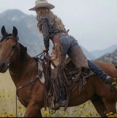 a woman riding on the back of a brown horse