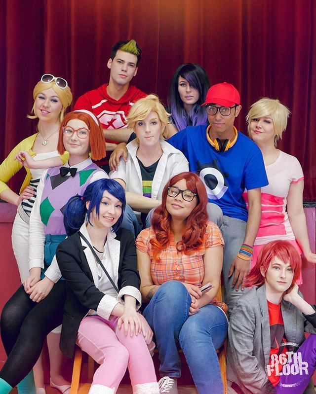 a group of young people posing for a photo together in front of a red curtain