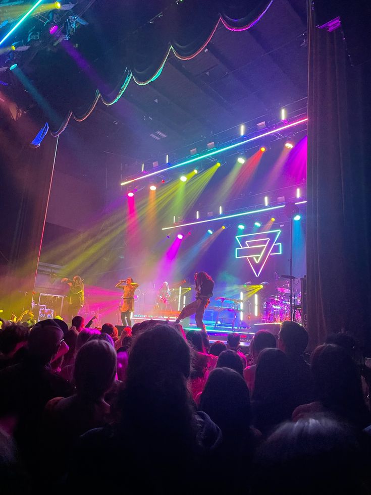 a group of people standing on top of a stage in front of a large crowd