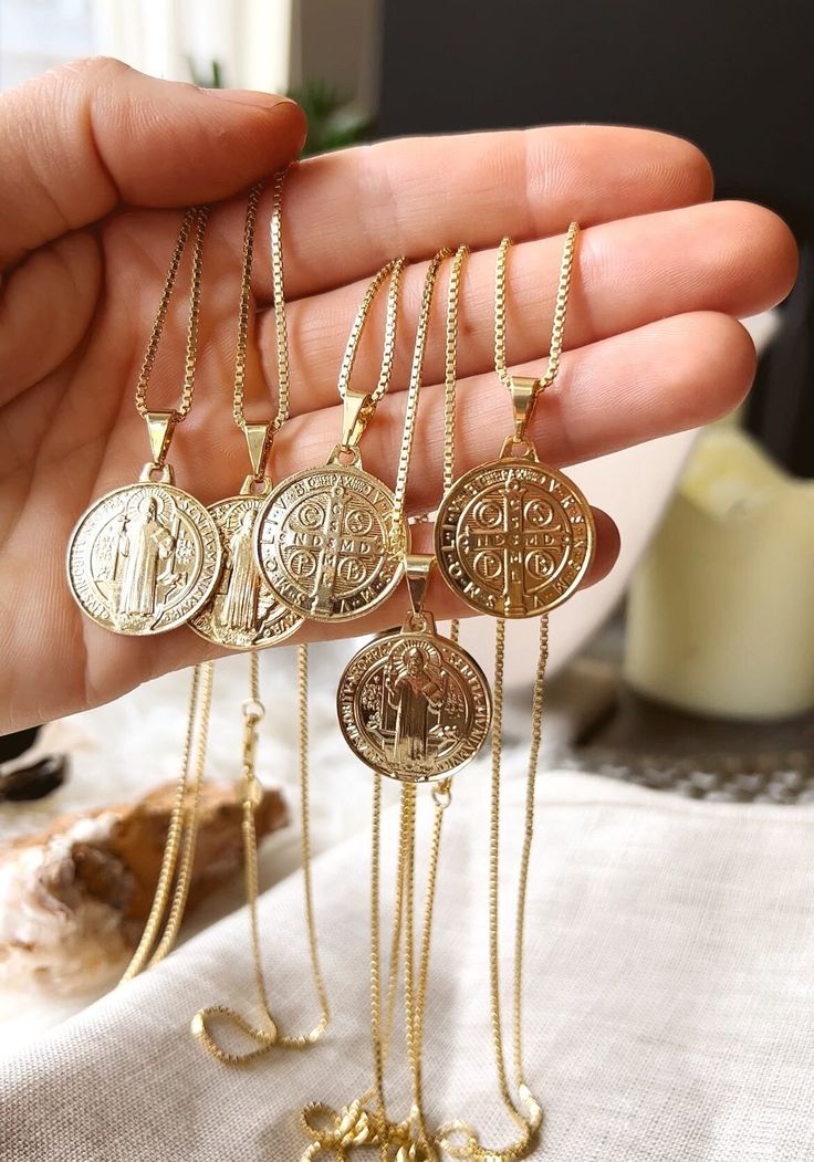 As one of the most identifiable religious coins,  Our double sided, traditional Saint Benedict pendant has a rich religious history and a coveted meaning. Popularly known as the Saint of protection from evil.  ✦ Gold filled Box, Ball, or Figaro chain measures 20 inches / 18K Gold Filled ✦ Two-sided pendant measures .75 inches / 18K GF Our jewelry is hypo allergenic and tarnish resistant, lasting many years. Spiritual Gold Plated Coin Pendant Charm Necklace, Spiritual Gold Plated Charm Necklace With Coin Pendant, Spiritual Gold-plated Engraved Coin Necklace, Spiritual Gold Plated Engraved Coin Necklace, Spiritual Coin-shaped Medallion Necklace With Locket, Spiritual Coin Medallion Necklace With Locket, Spiritual Medallion Coin Necklace With Locket, Gold Spiritual Coin Necklace, Gold Medallion Amulet Coin Necklace