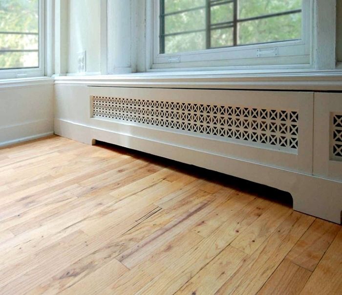 an empty room with wood flooring and white painted window frames on the side wall