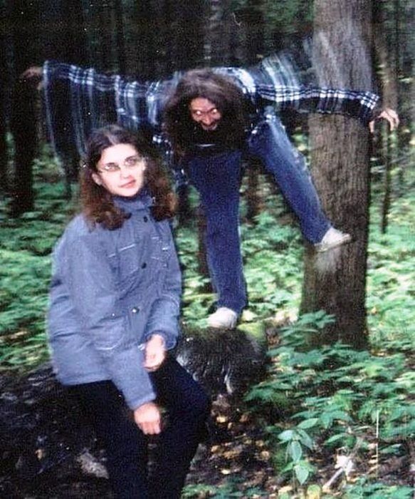 two people are hanging upside down in the woods