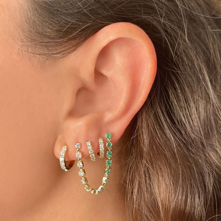 Go green with the Ear Stylist's Diamond and Emerald Draped Studs Perfect for any double piercing, this piece features a string of 7 brilliant white diamonds totaling .42 cts and 7 gorgeous green emeralds totaling .55 cts. Available in 14K Yellow Gold. Chain is approximately 2" in length. Sold Individually Luxury Green Diamond Earrings With Prong Setting, Luxury Green Diamond Earrings With Accents, Green Brilliant Cut Diamond Earrings, Green Diamond Earrings Fine Jewelry, Green Diamond Earrings In Fine Jewelry Style, Green Diamond Earrings With Diamond Accents, Green Round Diamond Earrings Fine Jewelry, Green Diamond Earrings With Sparkling Stones, Green Gemstone Diamond Earrings