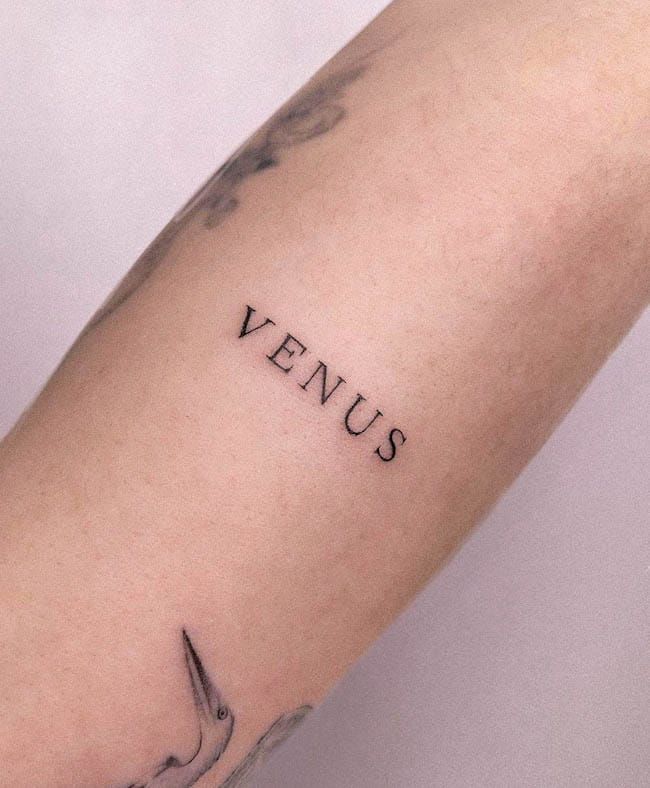 a person with a tattoo on their arm that says venus