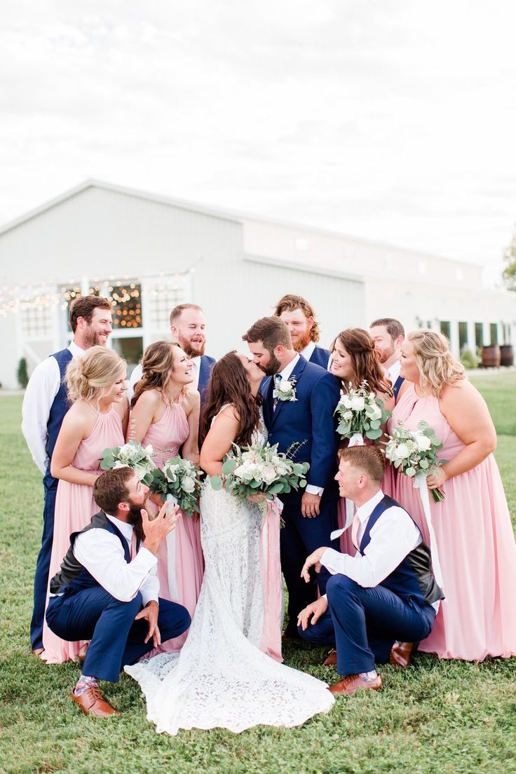 a group of people standing next to each other in front of a building with flowers