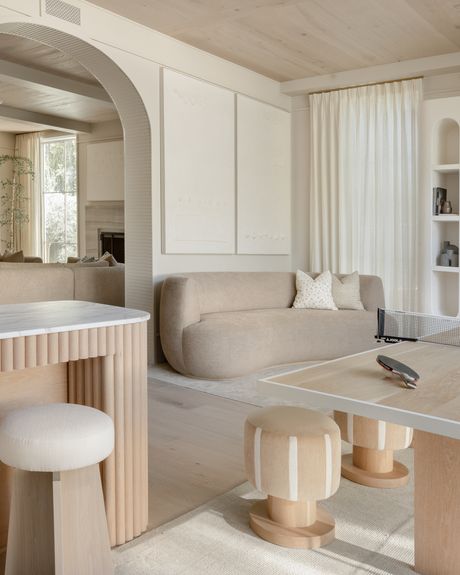 a living room filled with furniture next to a kitchen