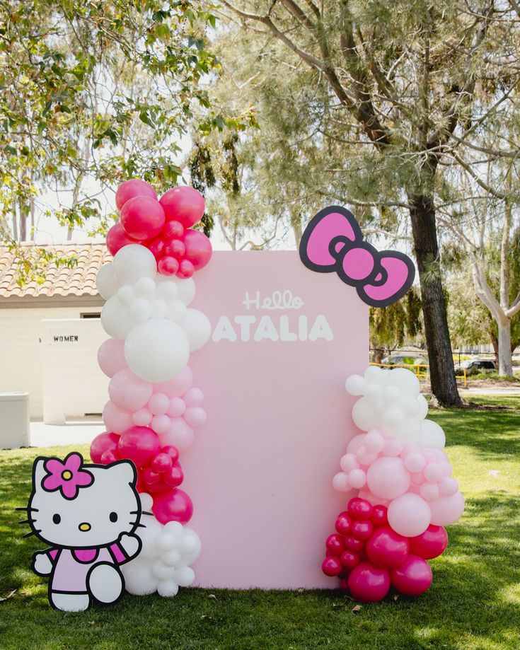 a hello kitty balloon arch with pink and white balloons