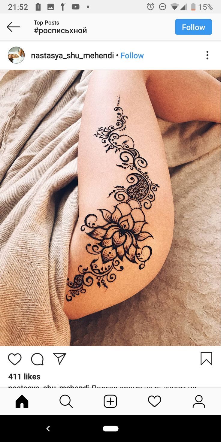 a woman laying on top of a bed next to her stomach covered in hendi tattoos