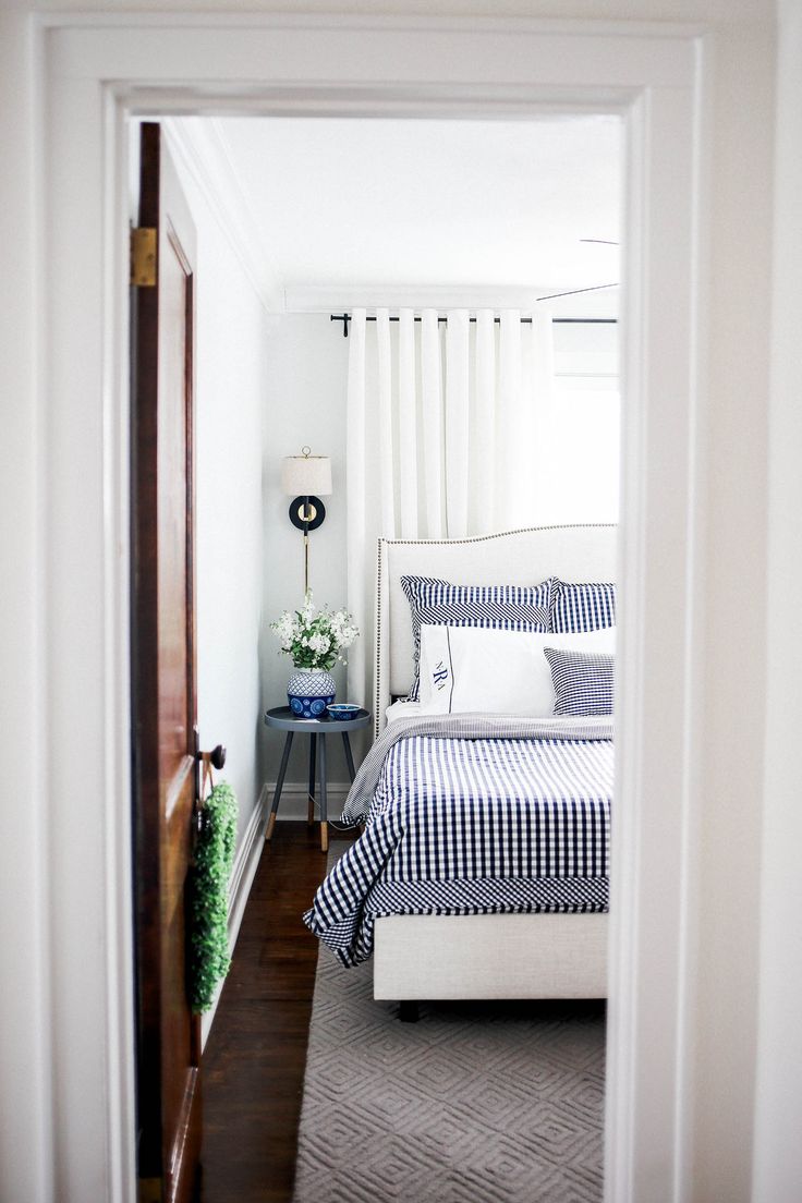 a white bed sitting next to a window in a bedroom