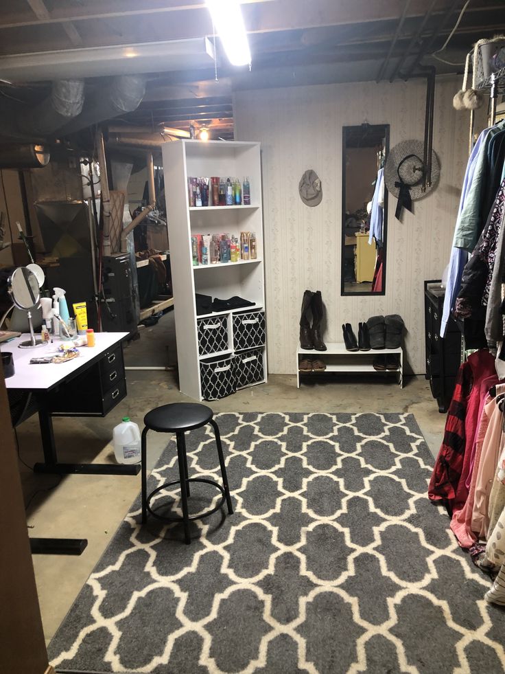 a room that has some clothes hanging on the wall and a stool in front of it