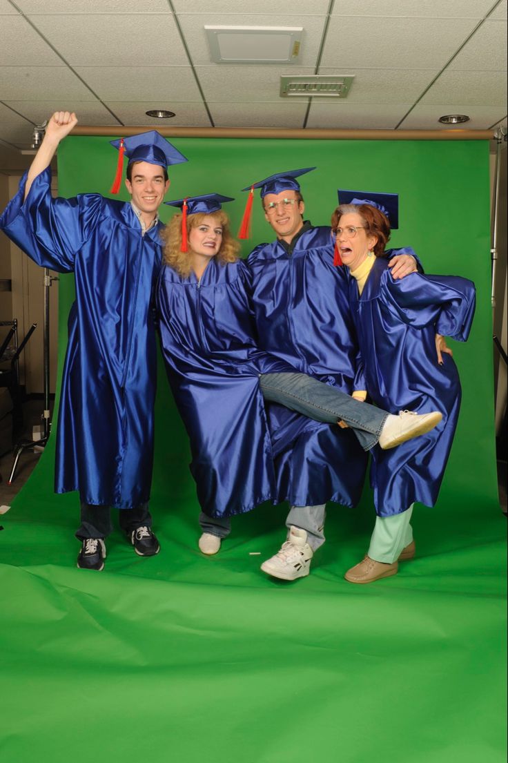 a group of people in graduation gowns posing for a photo on a green screen