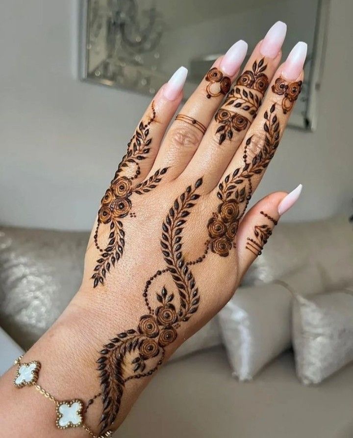 a woman's hand with henna tattoos on it