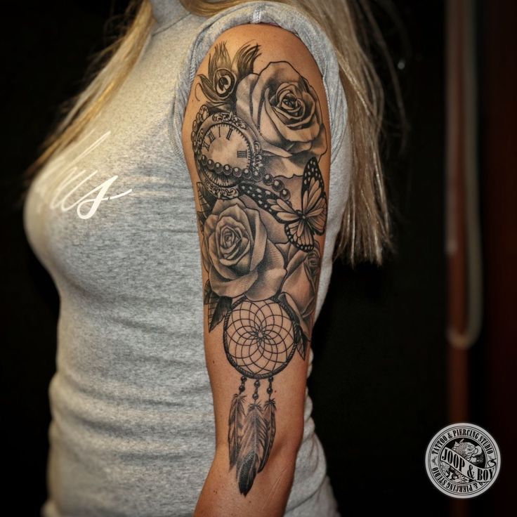 a woman with a tattoo on her arm holding a rose and a dream catcher in front of her shoulder