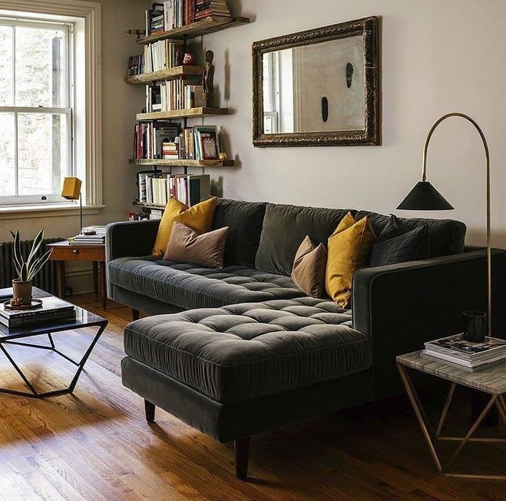 a living room filled with furniture and bookshelves next to a wooden flooring