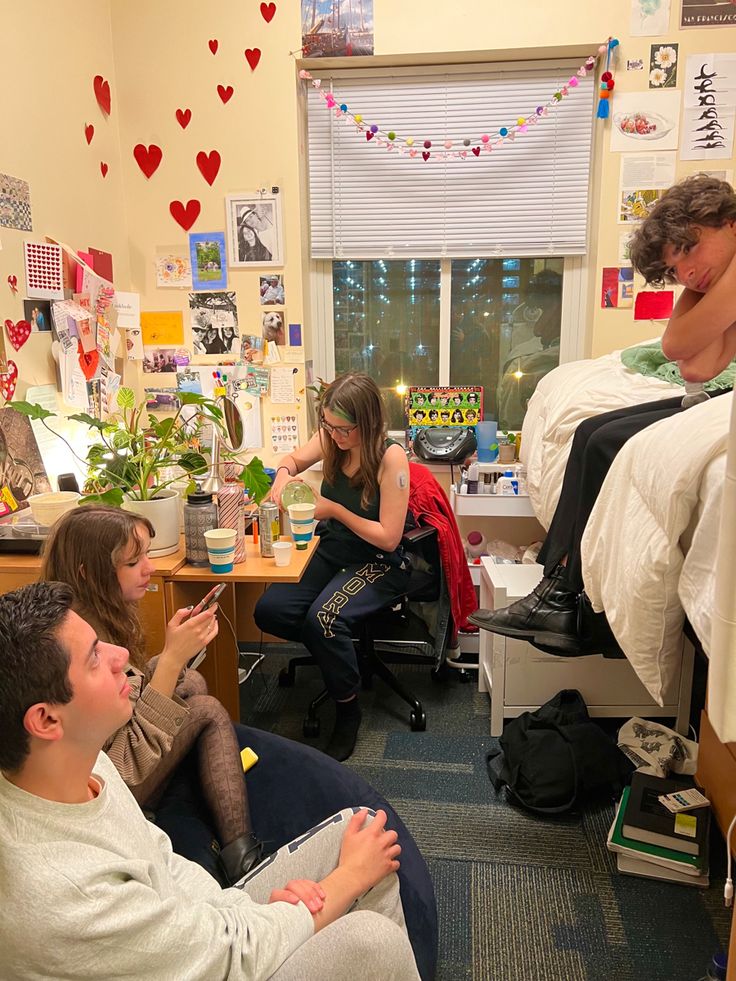 a group of people sitting around in a dorm room