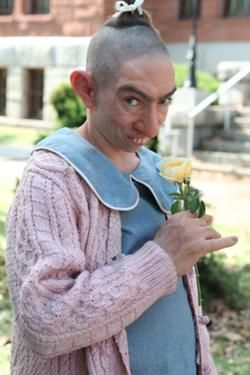 a man with a shaved head holding a flower