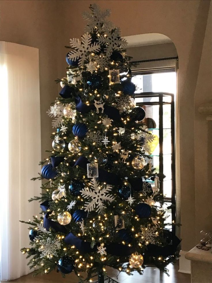 a decorated christmas tree with blue and silver ornaments