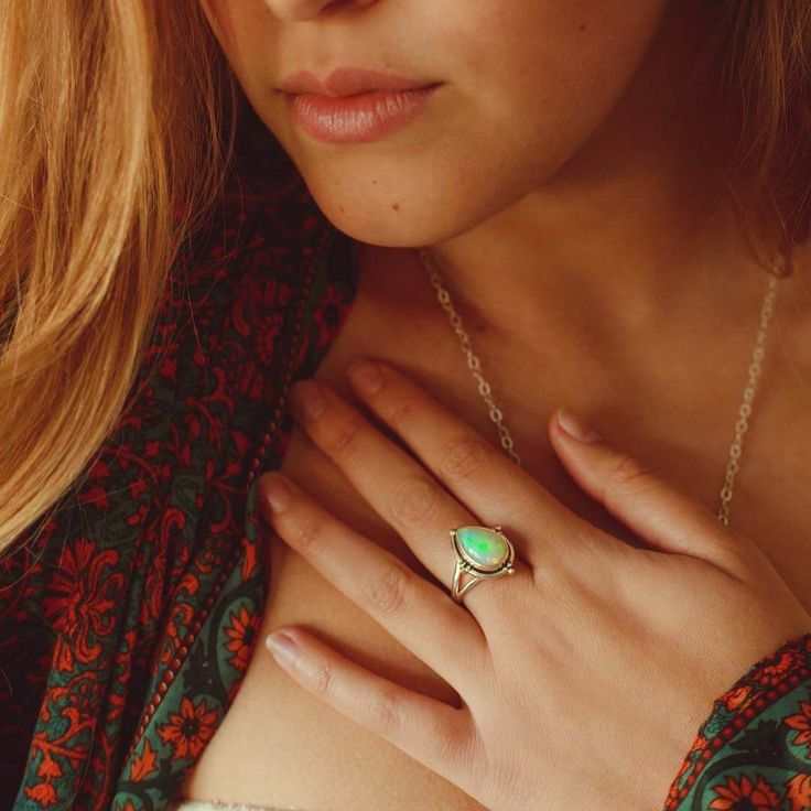 Unleash your inner fire with an opal teardrop ring, crafted from shimmering sterling silver. The delicate teardrop-shaped gem captures the light with its iridescent rainbow hues, making it the perfect addition to any jewelry collection*Our jewelry features natural, genuine gemstones, ensuring each piece is unique and one-of-a-kind. Please note that, as no two gemstones are identical, the jewelry you receive may vary from the photos.For wide-band rings, we recommend sizing up for the best fit.Mat Adjustable Fine Jewelry Opal Ring, Sterling Silver Opal Birthstone Ring, Sterling Silver Opal Ring Birthstone, Mystical Teardrop Sterling Silver Jewelry, Dainty Teardrop Adjustable Rings, Spiritual Teardrop Gemstone Rings, Mystical Teardrop Jewelry For Gifts, Silver Teardrop Opal Promise Ring, Teardrop Moonstone Ring In Sterling Silver