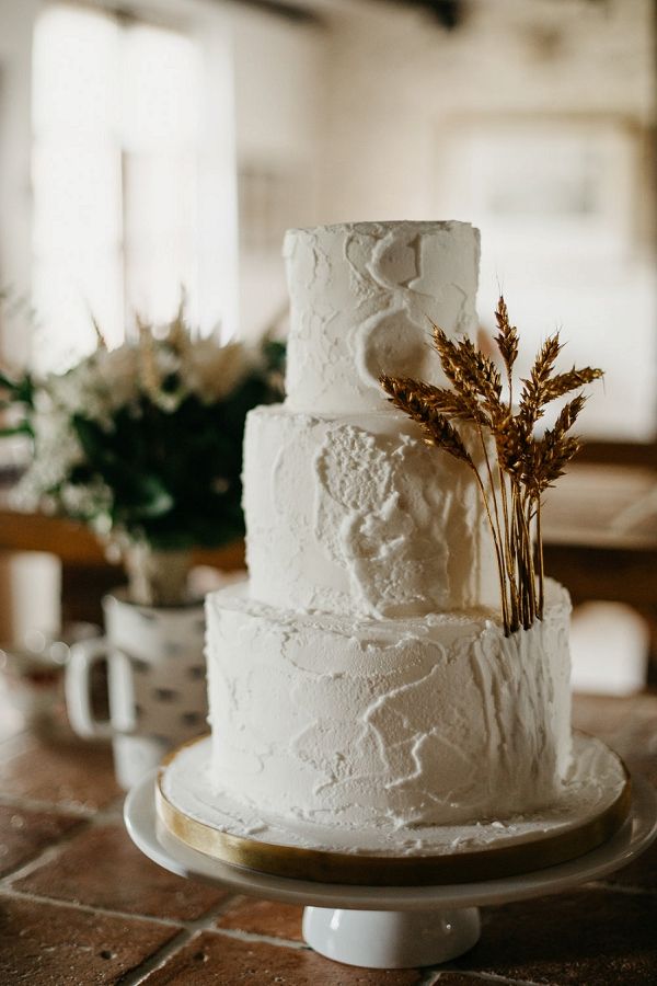 a three tiered white cake sitting on top of a table