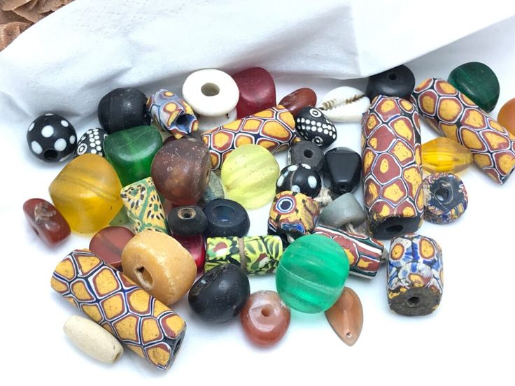 a pile of glass beads sitting on top of a white table next to a paper bag