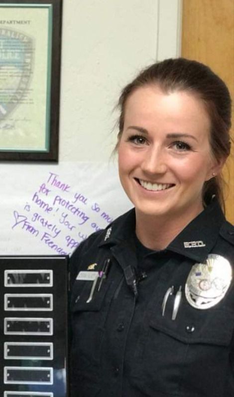 a woman police officer holding up a plaque