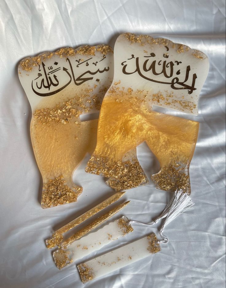 two pieces of gold and white shading with arabic writing on them