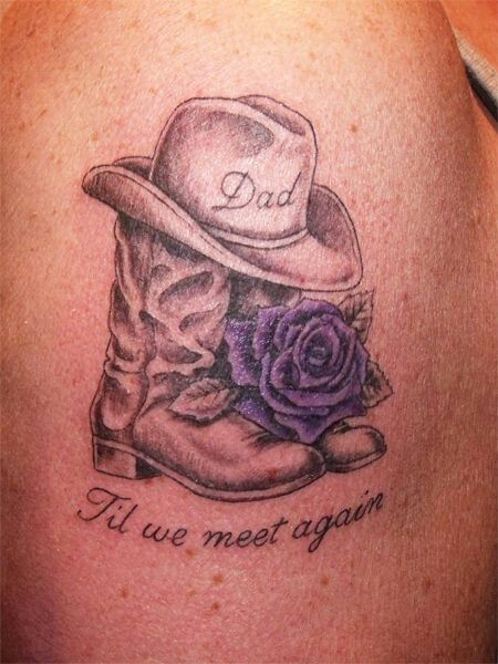 a tattoo on the back of a woman's shoulder with a cowboy hat and boots