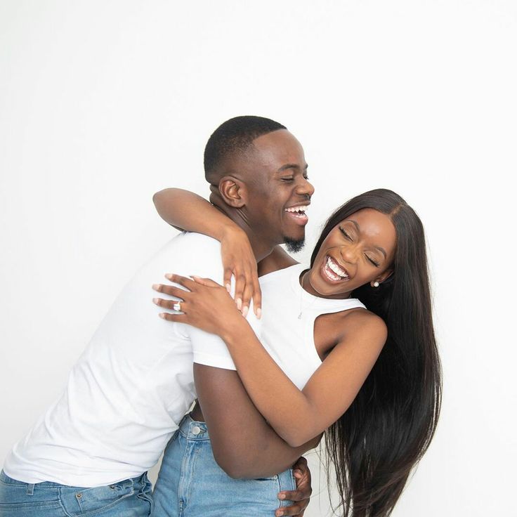 a man and woman hugging each other in front of a white background