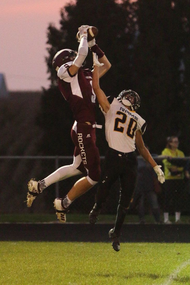 two football players jumping up in the air