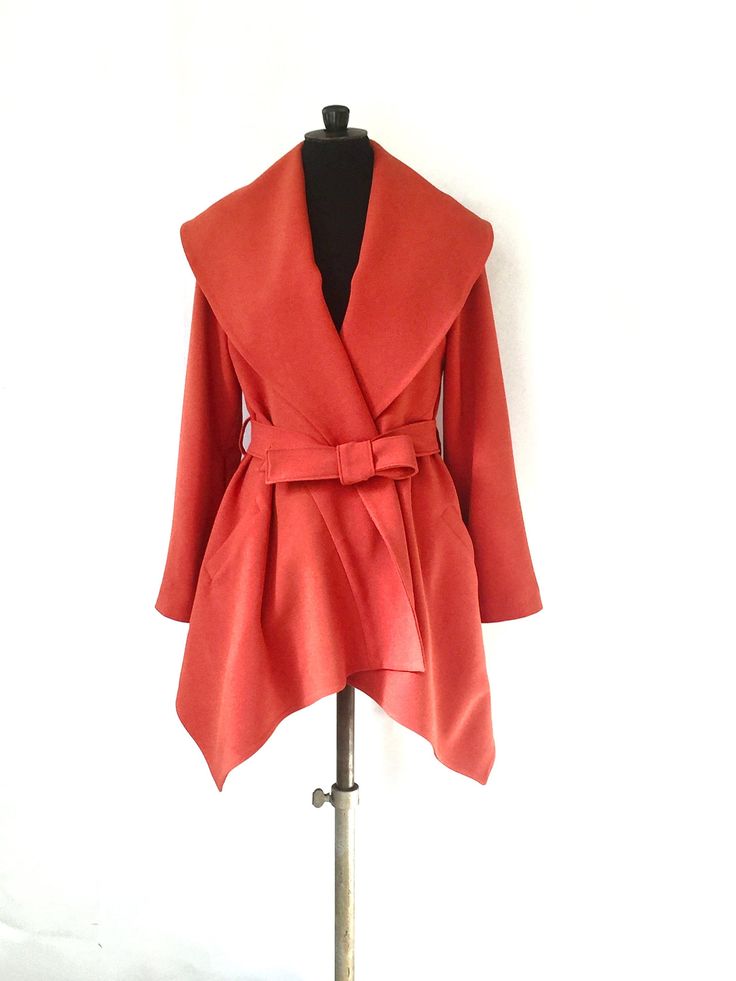 The jacket is made of a dark orange color crepe fabric (polyester and elasthanne). The jacket has an asymmetric cut (longer on the front), a big shawl collar, two pockets and a belt. Size: M (Fr size: 40) Length: Front: 90 cm - Back: 70 cm Composition: 97% Polyester - 3% Elasthanne Care of clothing: Dry cleaning only ! https://www.etsy.com/fr/shop/VLbasics?ref=seller-platform-mcnav Asymmetrical Formal Outerwear For Fall, Asymmetrical Formal Fall Outerwear, Formal Asymmetrical Fall Outerwear, Orange Outerwear For Office In Fall, Chic Orange Blazer For Fall, Elegant Fitted Orange Outerwear, Chic Orange Fall Blazer, Elegant Orange Office Outerwear, Formal Orange Outerwear For Fall