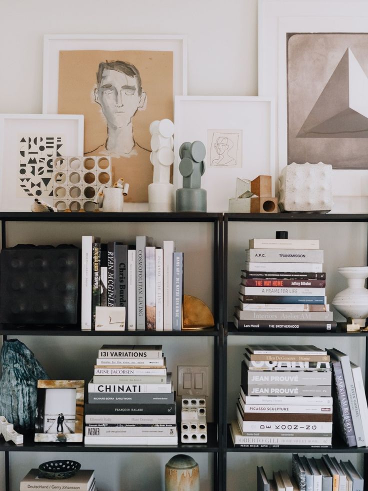 a bookshelf filled with lots of books next to pictures and other items on top of it