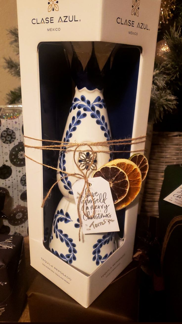 a white and blue vase sitting inside of a box