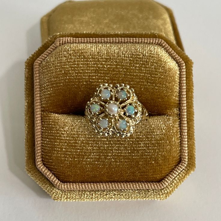 "Gorgeous vintage 14k yellow gold genuine opal & seed pearl cluster ring! This stunning retro piece features one genuine seed pearl center stone, surrounded by a halo of six genuine .66 ctw opal gems . The opals display a vibrant play-of-color, flashing orange, green, & violet hues. Lovely retro statement piece of fine jewelry circa 1970s, featuring October's birthstone!  ERA - Circa 1970s, Retro Era  METAL / MATERIAL - 14k yellow gold, 1 genuine seed  pearl , 6 genuine round cut opals ( approx. .66 CTW ) MARKINGS / HISTORY - Inside band is marked \"14k\" Skal SIZE / MEASUREMENTS - Size: 7.5, Ring Head Height: 14.2 mm, Rise off finger: 9.4 mm,Back of shank: 1.2 mm,Ring Weight: 4.98grams https://www.etsy.com/shop/LastCenturyJewels" Pearl Halo Ring, Gem Cluster, Pearl Cluster Ring, Retro Era, Pearl Cluster, Jewelry Lookbook, Wedding Rings Vintage, October Birthstone, Seed Pearl