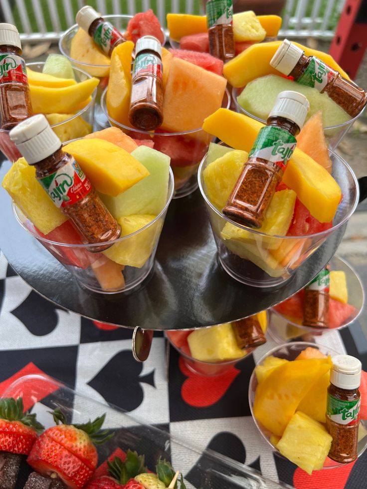 there are many different types of fruit in small bowls on the table with strawberries