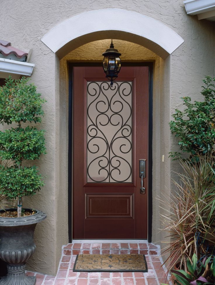 the front door is decorated with wrought iron designs and brick walkway leading up to it's entrance