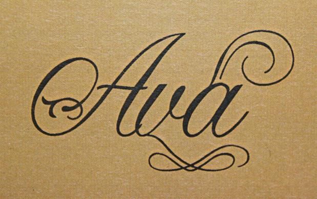 the word ald written in cursive writing on a piece of brown paper