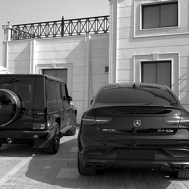 two mercedes benz vehicles parked in front of a building