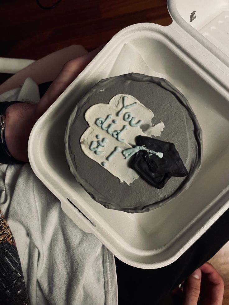 a person holding a cake with writing on it