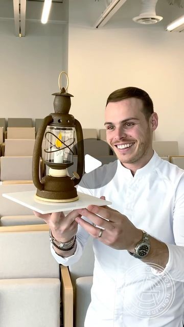 a man holding a tray with a lantern on it