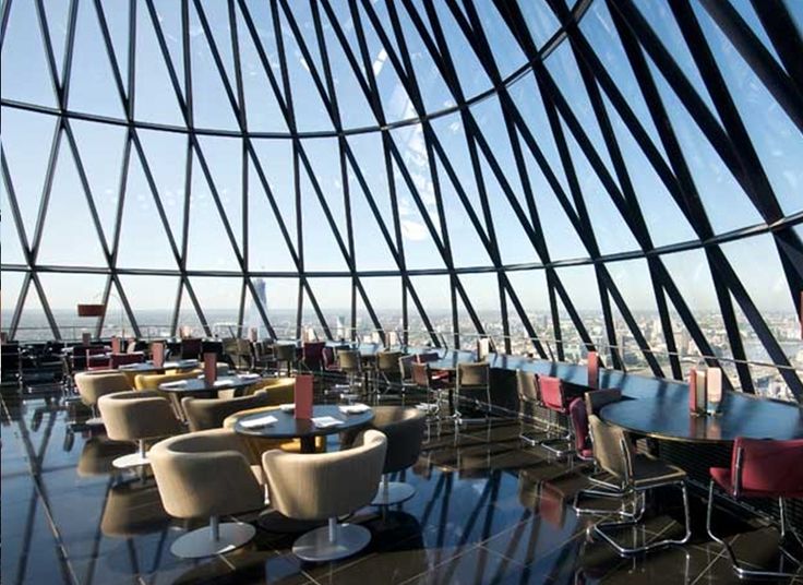 the inside of a building with tables and chairs on it's glass flooring