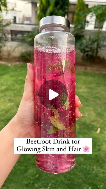 a person holding up a water bottle with flowers on it and the words, better drink for glowing skin and hair