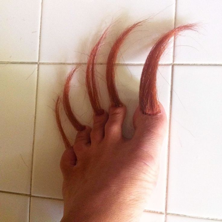 someone has their foot on the floor with red hair sticking out of it's toe