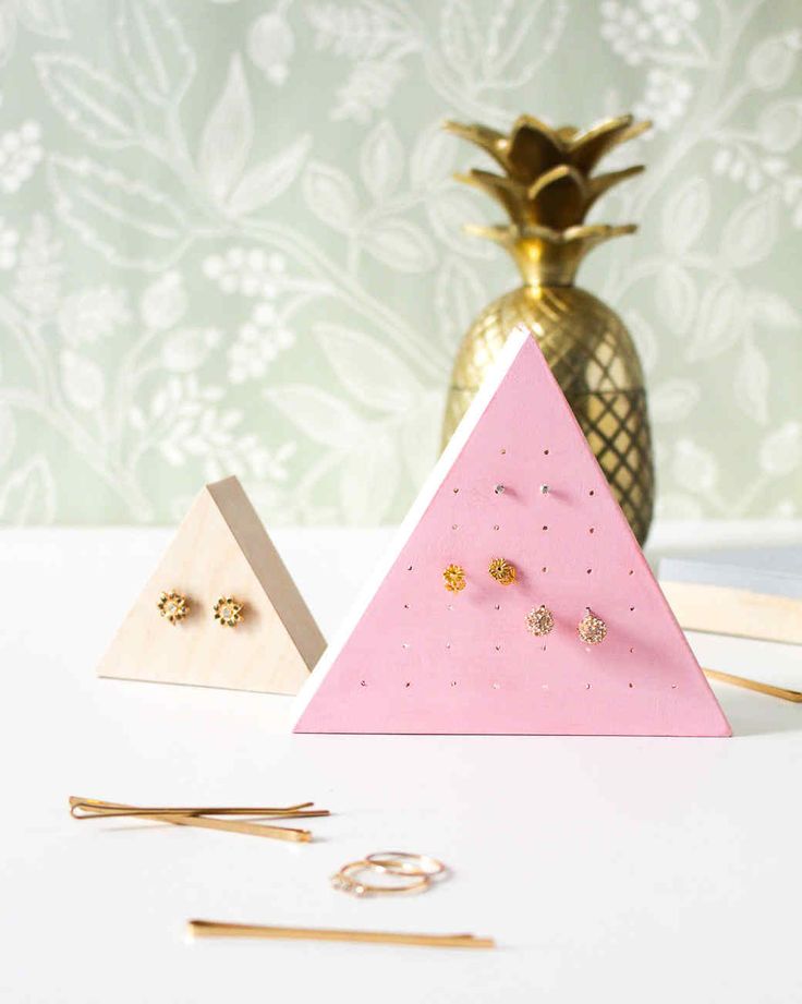 three pieces of jewelry are sitting on a table next to a pineapple and other items