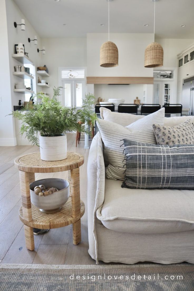 a living room filled with lots of furniture and plants on top of a wooden table