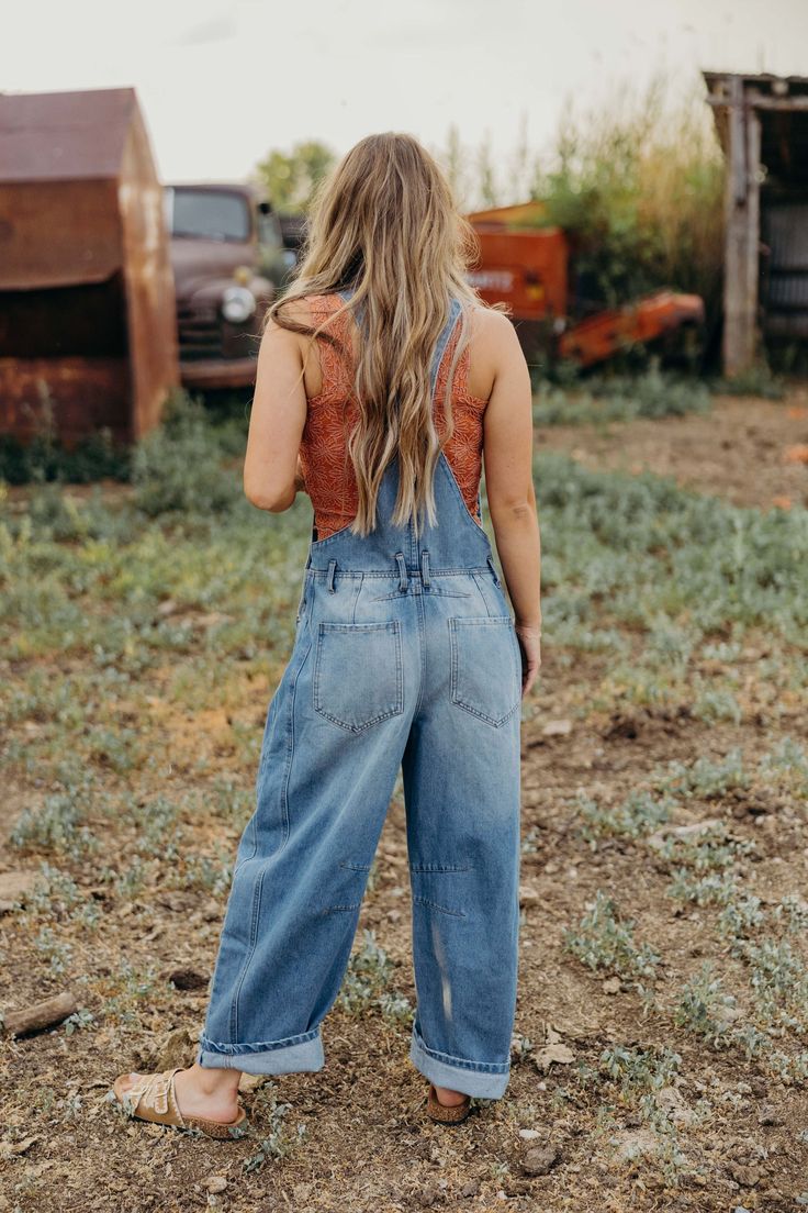 The Flynn Overalls offer a stylish and versatile option for your fall wardrobe. With a barrel jean fit and loose silhouette, these cowgirl overalls provide both comfort and fashion. Made from durable denim, they are perfect for back to school or any casual occasion. Courtney is wearing size small paired with The Kristan Tank Cowgirl Overalls, Jean Fit, Overalls Outfit, Bib Overalls, Curvy Dress, Heritage Collection, Fall Wardrobe, Short Pants, Bottoms Pants