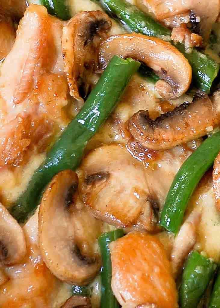 a pizza with chicken, green beans and mushrooms