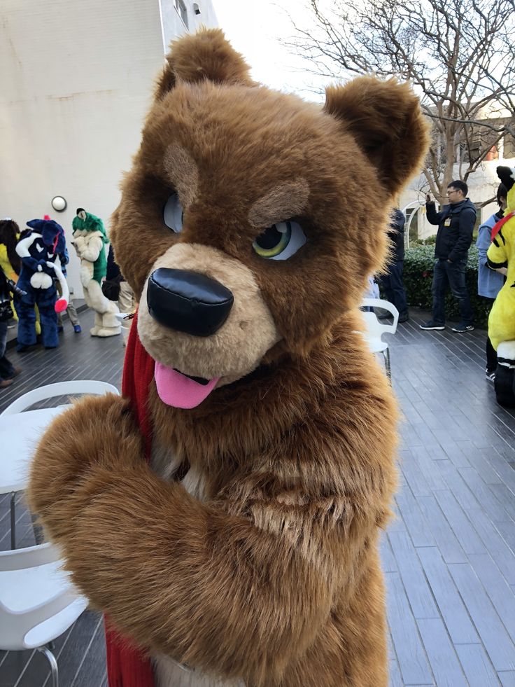 a large brown bear standing on top of a wooden floor