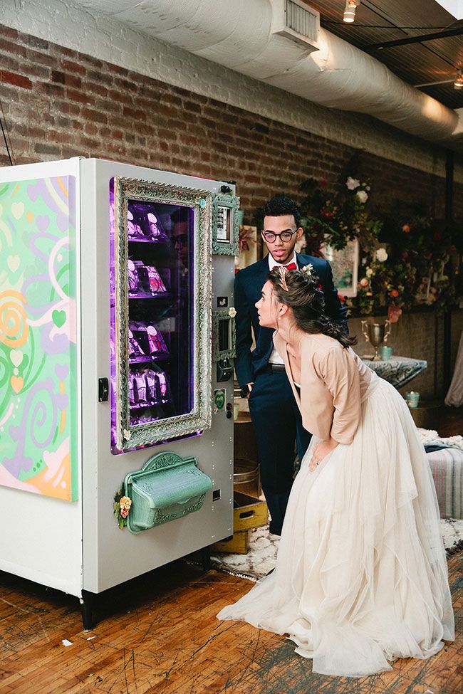 a bride and groom are looking at an old fashioned vending machine that is on display