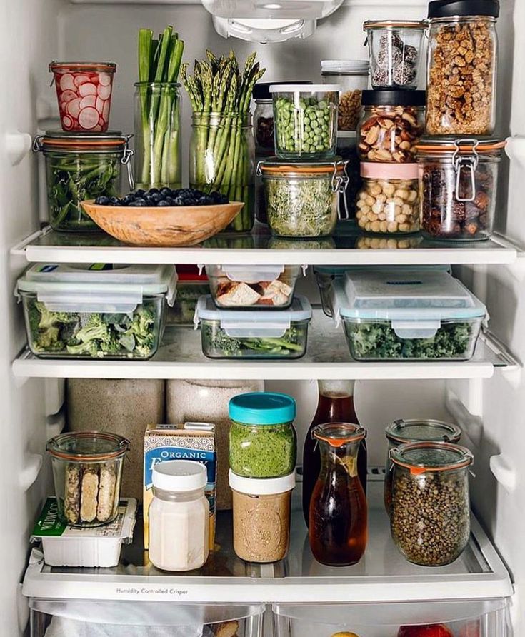 an open refrigerator filled with lots of food and condiments on the bottom shelf