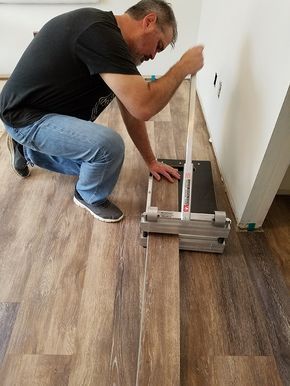 a man is working on the floor in his kitchen with a tool box and screwdriver